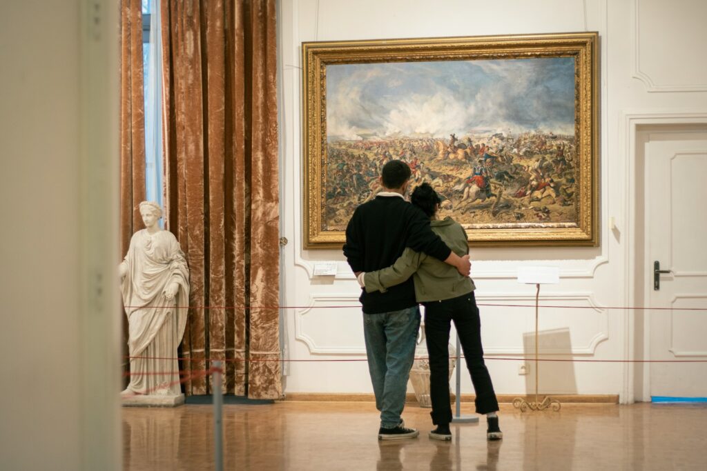 a man and a woman standing in front of a painting